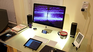 silver iMac computer set on top of white wooden table