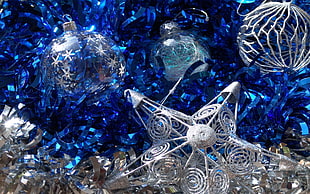 silver christmas ornaments on blue tinsels