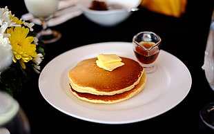 selective focus photography of plate of pancakes with butter and honey