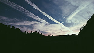 silhouette photo of houses, clouds, rooftops