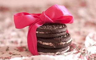 three chocolate biscuits with pink ribbon