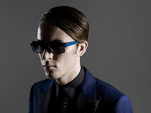 man wearing black and blue framed sunglasses and suit