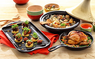 photo of foods on black skillet, bowl, and tray