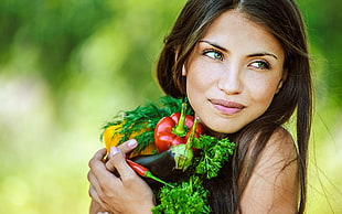 woman holding vegetables close-up photo