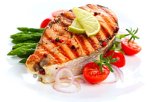 grilled salmon top with sliced lemon and tomatoes and onions