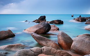 brown stones near body of water under blue sky HD wallpaper