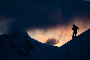 silhouette of person climbing on snowy mountain HD wallpaper