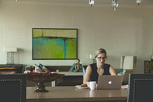 women wearing black sleeveless top while using MacBook Air
