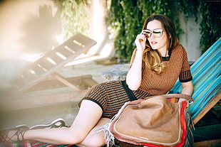 woman wearing brown and black crew-neck shirt with shorts on chaise lounge