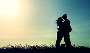 silhouette of man and woman on grass field HD wallpaper