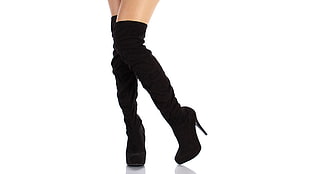 person wearing black suede cone heeled knee-high boots
