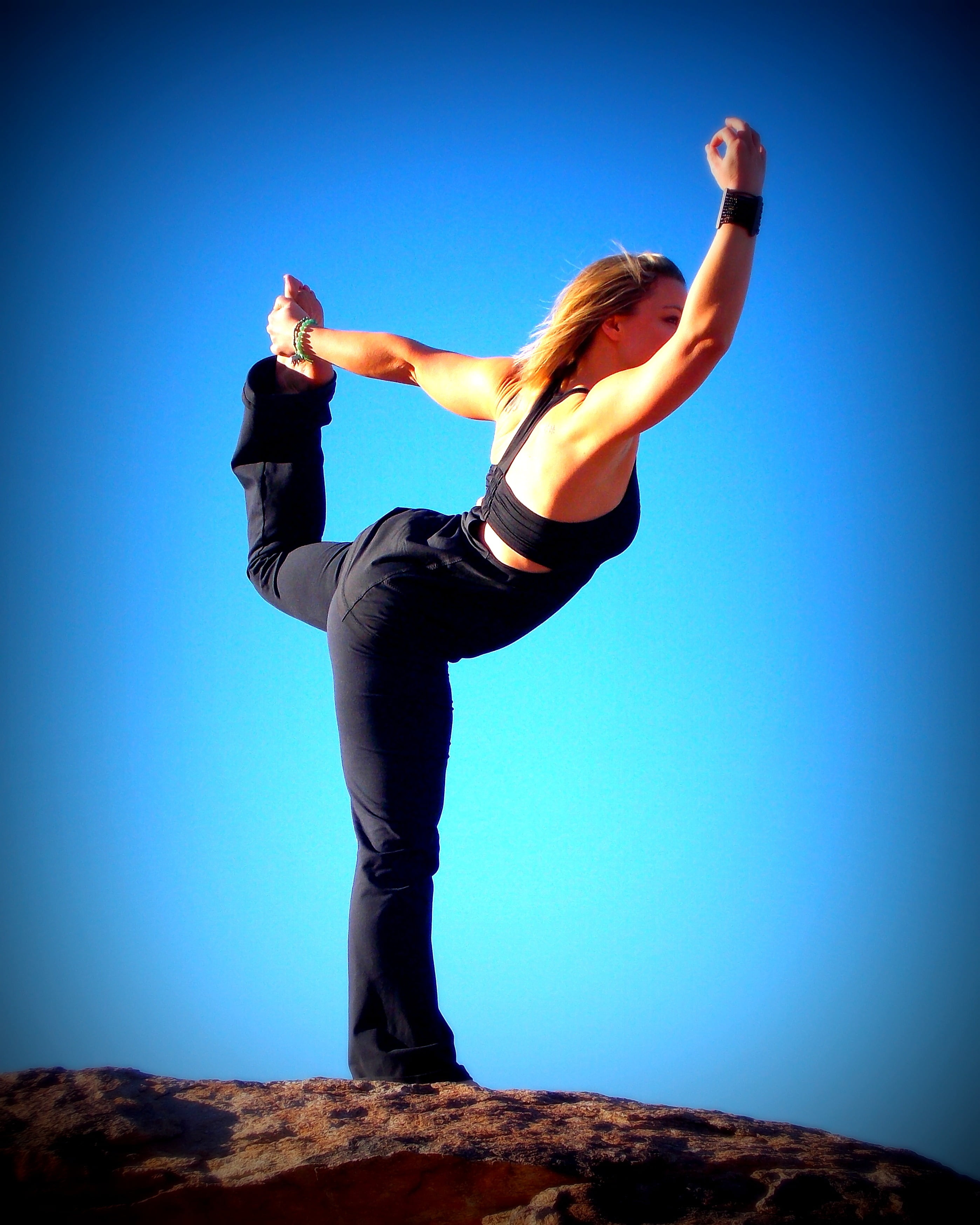 woman bending her left foot raising her right hand