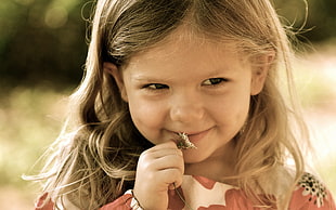 close up photo of girl biting brown hair clamp during daytime