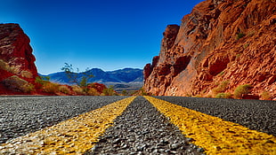 photo of road between brown mountains