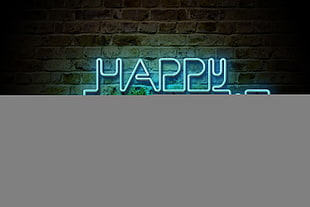lighted happy new year neon sign on brown concrete surface