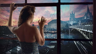 woman wearing gray top standing near glass window