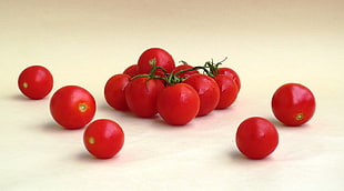 red tomatoes on brown wooden surface