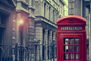 red telephone booth near black lamp post