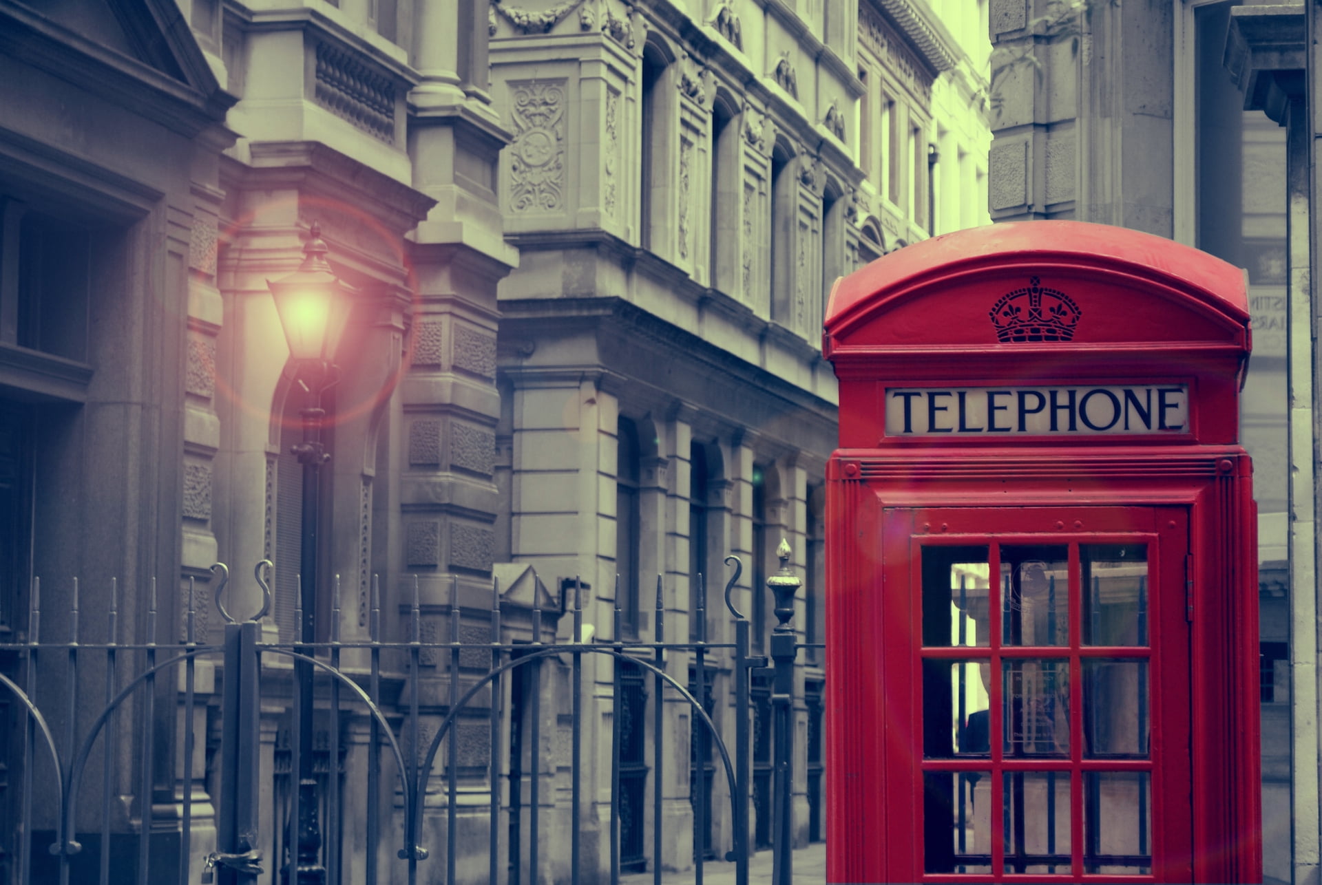 red telephone booth near black lamp post