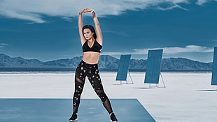 woman wearing sports bra and leggings doing stretching body