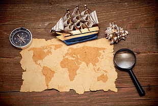 sailing ship, magnifying glass, conch shell, compass and map
