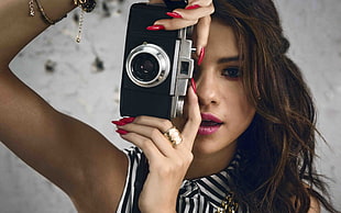 Selena Gomez taking black and gray point-and-shoot digital camera