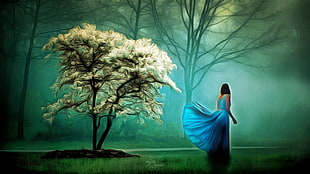 woman in blue sleeveless gown with white leafed tree painting