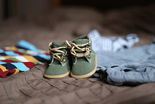 green-and-brown crib shoes on textile