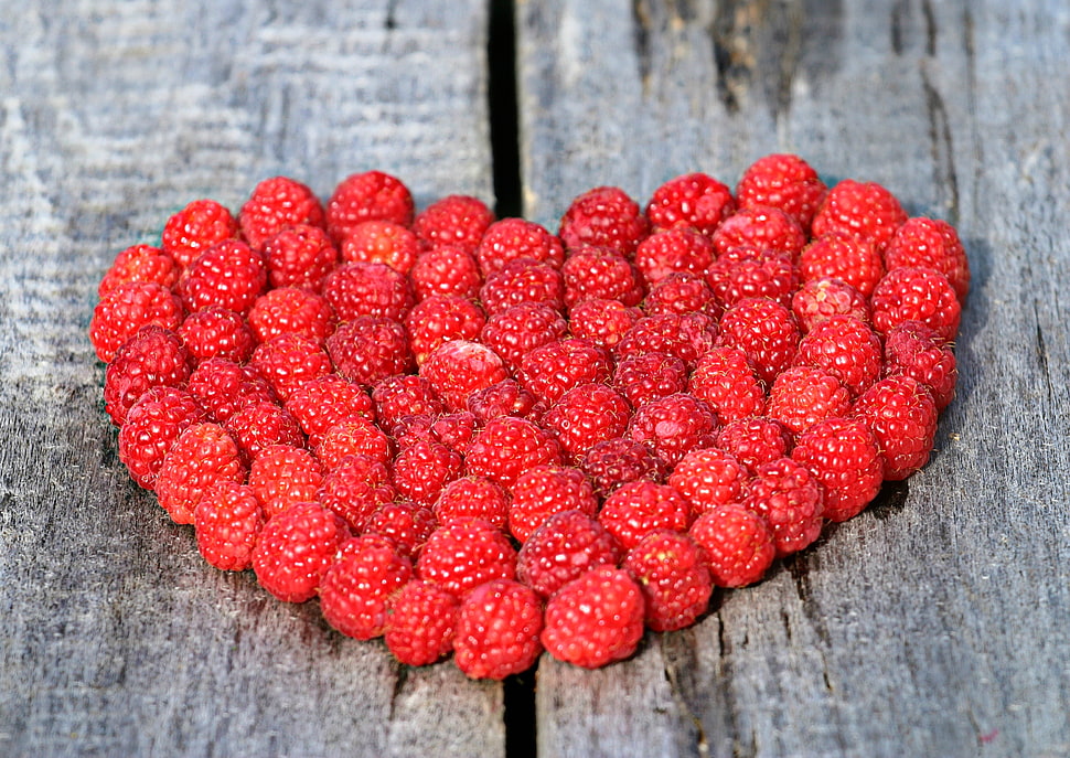bunch of raspberry in heart shape on brown surface HD wallpaper