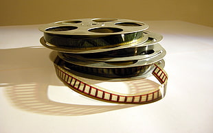 three film reels on white surface