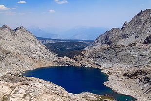 body of water surrounded by gray rock mountain under white and blue sky, sequoia national park