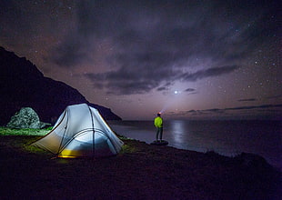 person standing near shore during nighttime