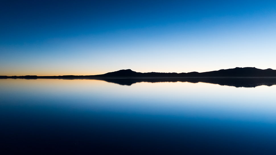 panoramic photo of island's silhouette near body of water at sunrise HD wallpaper