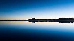 panoramic photo of island's silhouette near body of water at sunrise HD wallpaper