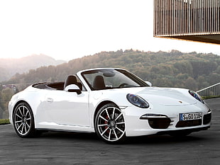 white Porsche Boxster parked near building during daytime