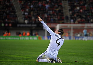 soccer player number 4 pointing up while taking photo on soccer field HD wallpaper