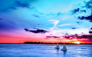 landscape photography of a two sailboats in bodies of water