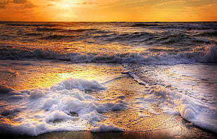 sea waves with bubbles during sunrise