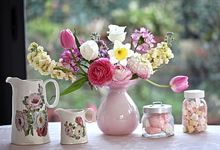 assorted flowers in pink ceramic vase