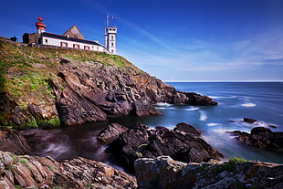 white lighthouse near blue ocean water during daytime HD wallpaper