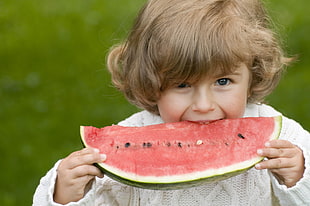 child eating sliced watermelon