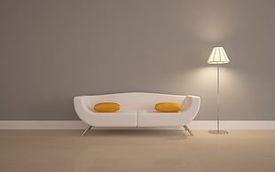 white fabric 2-seat sofa with two yellow throw pillows beside white lampshade floor lamp