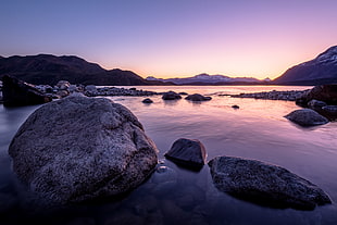 photo of rocks on body of water, lago