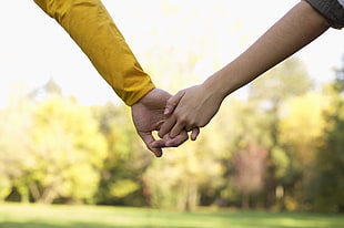 two person's hand holding hands