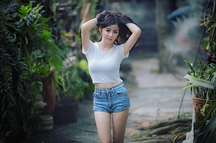 woman wearing white t-shirt and blue denim short shorts holding her hair photo HD wallpaper