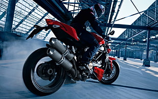 man riding red and black sports bike