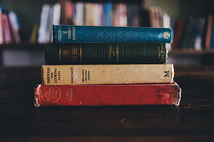 selective focus photography of four pile of books