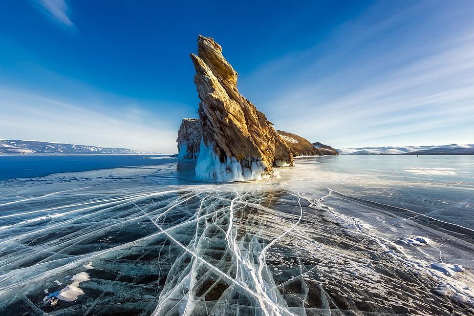 brown rock formation in middle of body of water HD wallpaper