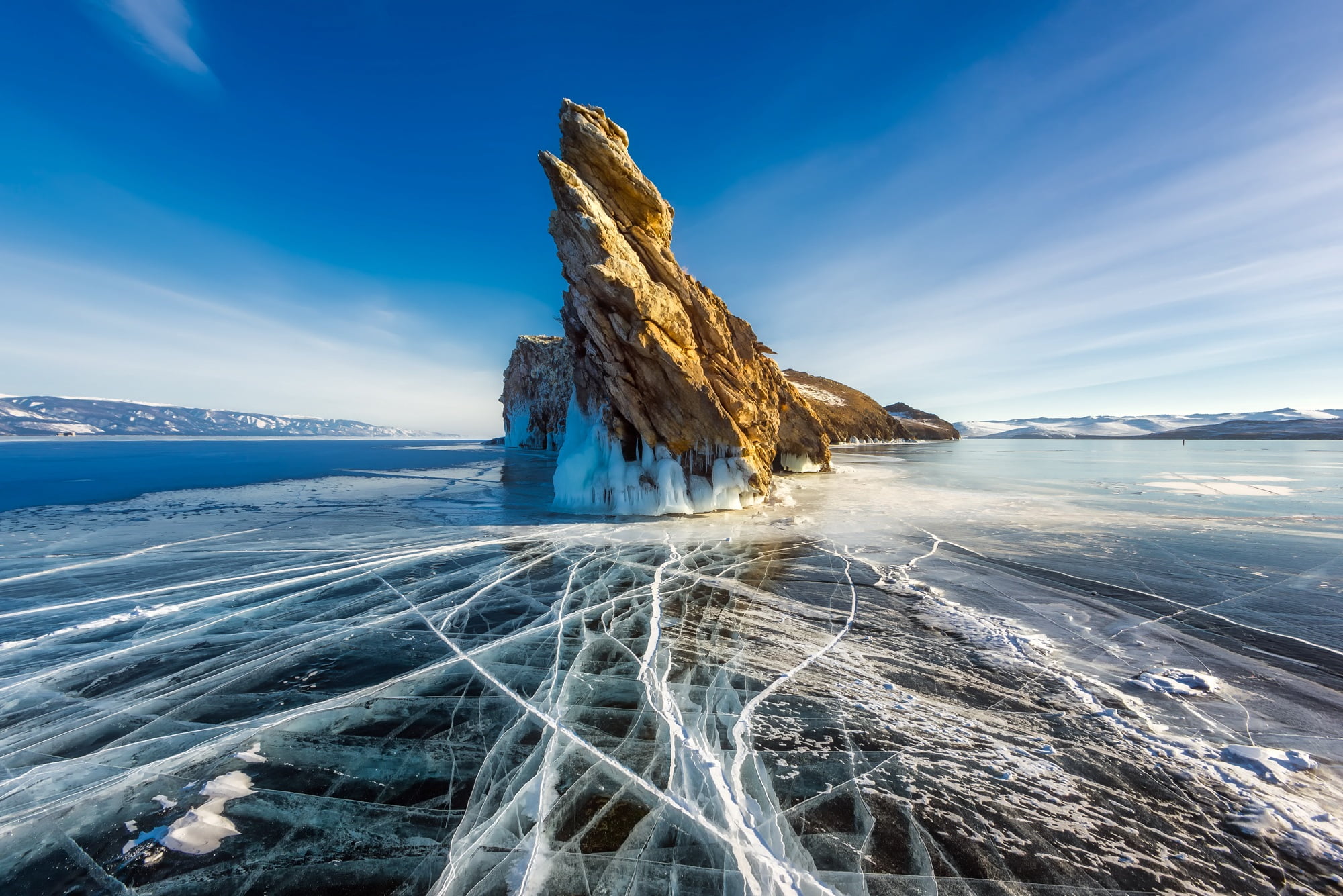 brown rock formation in middle of body of water