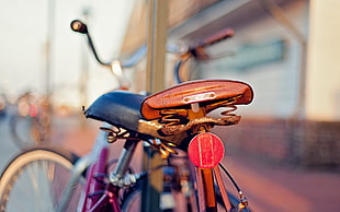 selective focus photography of bike saddle parked at street sided HD wallpaper